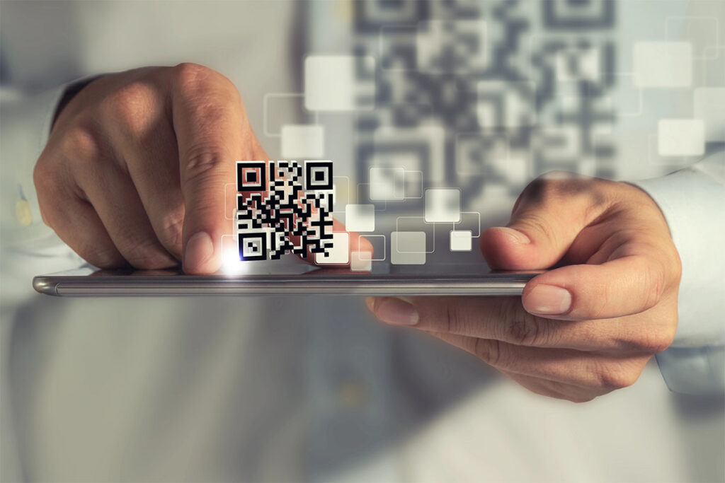 A person pointing at a smartphone displaying a QR code, with abstract digital squares in the background.