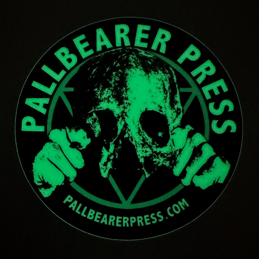 A glowing, circular logo featuring a skull with clenched fists and the text "PALLBEARER PRESS" at the top, and "pallbearerpress.com" at the bottom, set against a black background.